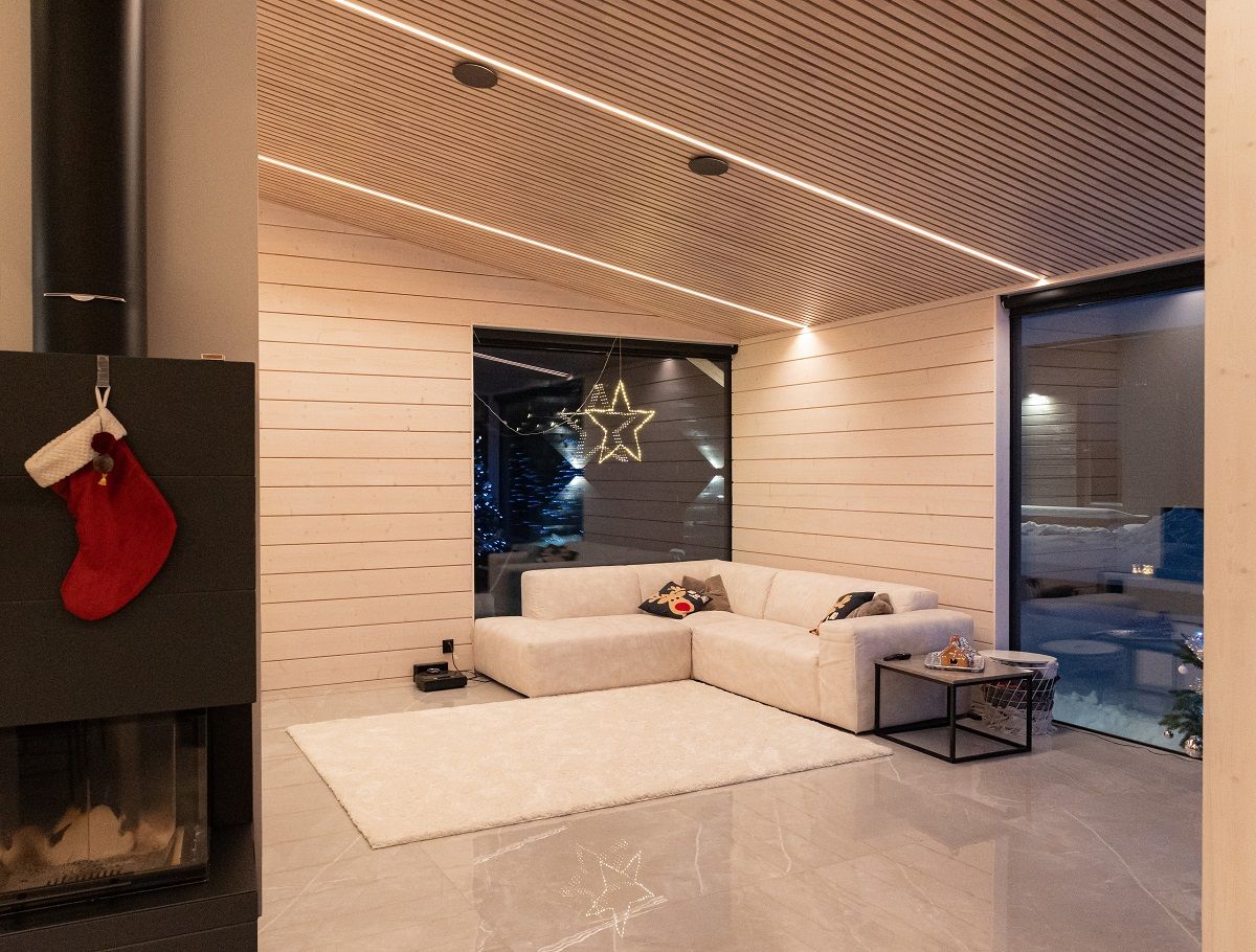 L'altezza del soggiorno è di oltre 3 metri e il nastro LED è sufficiente per illuminare lo spazio. Il nastro è regolabile in base alla temperatura del colore e la sua luce bianca calda mette in risalto il tono naturale del legno.